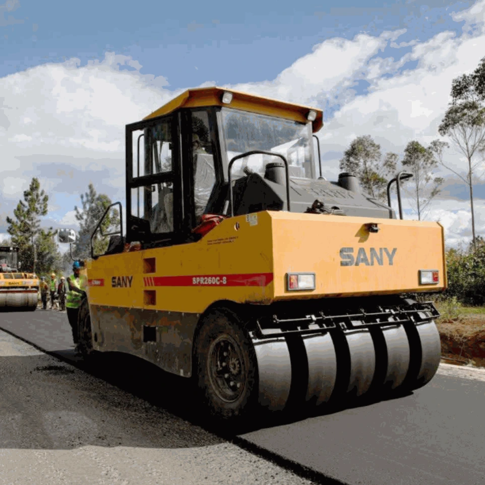 Trust Partners Geo-Group active road works site featuring heavy machinery, including graders and asphalt pavers, improving road infrastructure. Workers ensure quality and safety while enhancing transportation routes in Kenya
