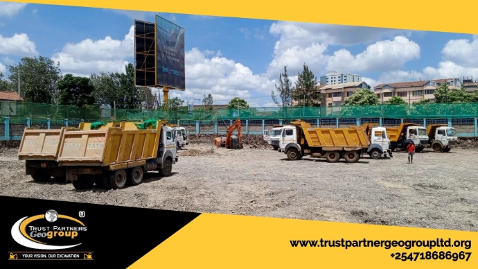 Heavy earthworks equipment in operation on a construction site in [Nairobi/Machakos/Kiambu/Nakuru], including excavators and dump trucks, performing trenching and grading with on-site safety measures