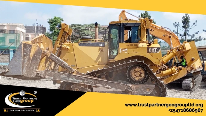 Heavy earthworks equipment in operation on a construction site in [Nairobi/Machakos/Kiambu/Nakuru], including excavators and dump trucks, performing trenching and grading with on-site safety measures