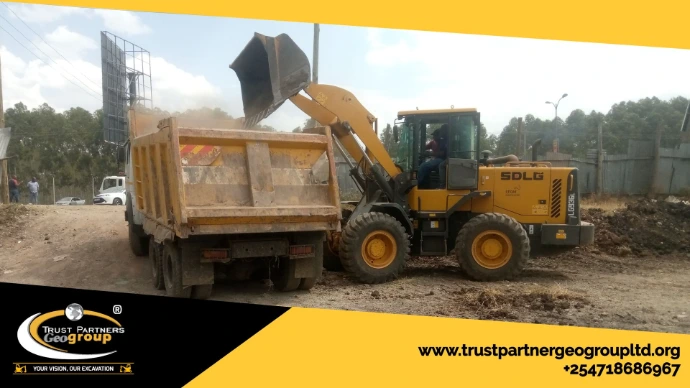 Heavy earthworks equipment in operation on a construction site in [Nairobi/Machakos/Kiambu/Nakuru], including excavators and dump trucks, performing trenching and grading with on-site safety measures